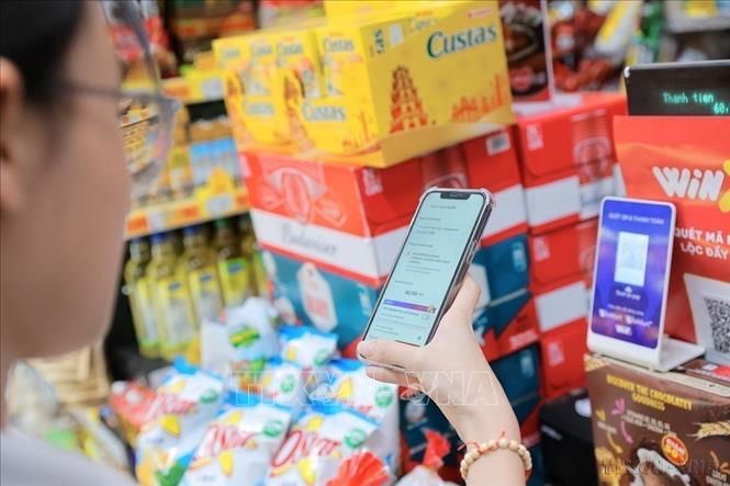 Nghị quyết số 57-NQ/TW ngày 22/12/2024 của Bộ Chính trị về đột phá phát triển khoa học, công nghệ, đổi mới sáng tạo và chuyển đổi số quốc gia. Trong ảnh: Người dân sử dụng mã QR để thanh toán tại các cửa hàng, siêu thị và điểm bán lẻ. Ảnh: Lê Đông – TTXVN