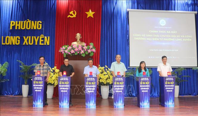 Đại biểu thực hiện nghi thứ ra mắt và đưa vào vận hành Hệ sinh thái chuyển đổi số và Cổng thương mại điện tử phường Long Xuyên, tỉnh An Giang. Ảnh: Công Mạo -TTXVN