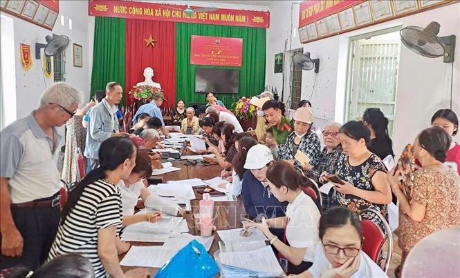 Tổ chức điểm giao dịch lưu động, tăng cường phối hợp với các ngân hàng, đơn giản hóa quy trình, bố trí lực lượng hỗ trợ tại chỗ hướng dẫn người dân các bước sử dụng tài khoản. Ảnh: TTXVN phát