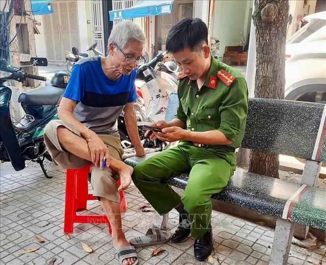 Hướng dẫn người cao tuổi thao tác các bước sử dụng tài khoản. Ảnh: TTXVN phát