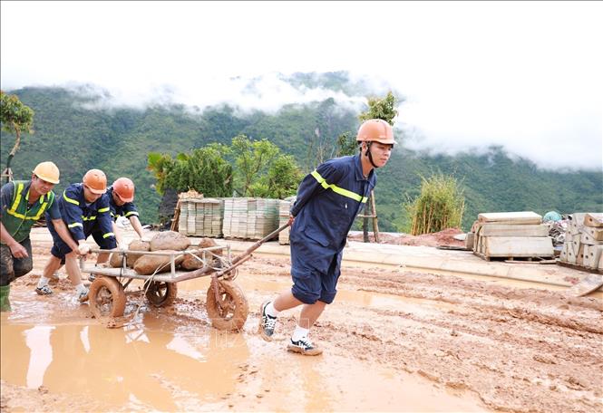 Các lực lượng tham gia hỗ trợ vận chuyển trang thiết bị góp phần đẩy nhanh tiến độ hoàn thiện công trình tại Trường PTNT Tiểu học và THCS tại xã Pa Tần. Ảnh: Quý Trung – TTXVN