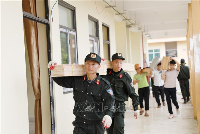 Các lực lượng tham gia hỗ trợ vận chuyển trang thiết bị góp phần đẩy nhanh tiến độ hoàn thiện công trình tại Trường PTNT Tiểu học và THCS tại xã Pa Tần. Ảnh: Quý Trung – TTXVN
