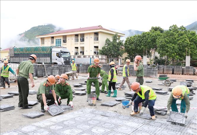 Cán bộ chiến sĩ cùng các lực lượng đóng trên địa bàn ra quân thực hiện chiến dịch cao điểm 100 ngày đêm hỗ trợ xây dựng các trường PTNT Tiểu học và THCS tại xã Pa Tần. Ảnh: Quý Trung – TTXVN