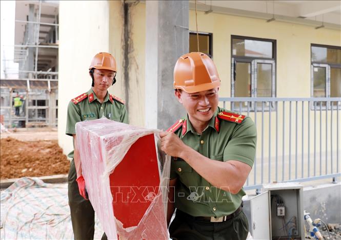 Cán bộ chiến sĩ công an tỉnh Lai Châu tham gia hỗ trợ vận chuyển các thiết bị tại Trường PTNT Tiểu học và THCS tại xã Pa Tần. Ảnh: Quý Trung – TTXVN