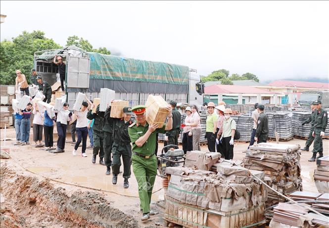 Cán bộ chiến sĩ công an tỉnh Lai Châu tham gia hỗ trợ vận chuyển các thiết bị tại Trường PTNT Tiểu học và THCS tại xã Pa Tần. Ảnh: Quý Trung – TTXVN