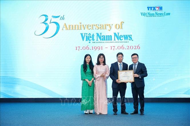 Nhà báo Lê Quốc Minh, Ủy viên Trung ương Đảng, Phó Trưởng Ban Tuyên giáo và Dân vận Trung ương, Tổng Biên tập Báo Nhân Dân, Chủ tịch Hội Nhà báo Việt Nam trao bằng khen cho đại diện báo Viet Nam News & Law. Ảnh: Phạm Tuấn Anh - TTXVN