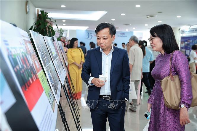 Khách mời xem trưng bày ảnh nhân dịp Báo Việt Nam News and Law kỷ niệm 35 năm phát hành số báo đầu tiên. Ảnh: Phạm Tuấn Anh - TTXVN
