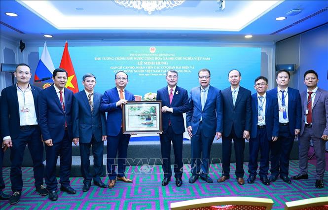 Thủ tướng Lê Minh Hưng tặng quà lưu niệm cho cộng đồng người Việt Nam tại Liên bang Nga. Ảnh: Dương Giang - TTXVN   
