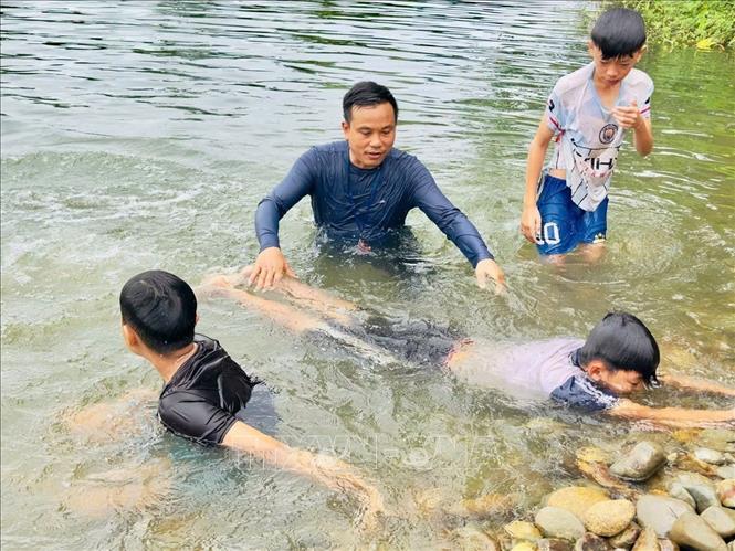 Đoàn viên, thanh niên và tình nguyện viên trực tiếp xuống nước hướng dẫn kỹ năng bơi, lặn cơ bản cho các em nhỏ trên địa bàn sông nước ở xã Sơn Hồng, Hà Tĩnh. Ảnh: Hoàng Ngà - TTXVN