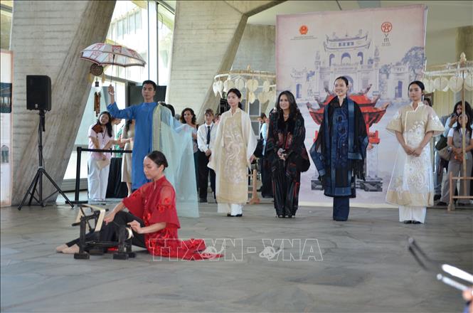 Ca sĩ Thanh Lam (áo đen đứng giữa) hát nền trong phần trình diễn áo dài của nhà thiết kế Minh Hạnh tại sự kiện. Ảnh: Hữu Chiến - PV TTXVN tại Pháp