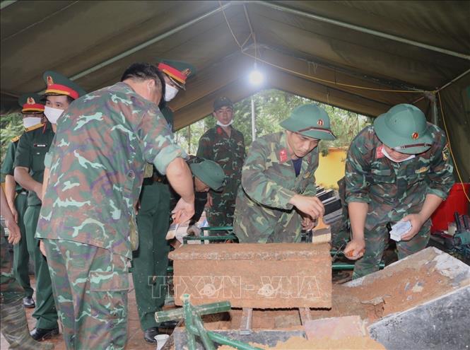 Lực lượng làm nhiệm vụ lấy mẫu hài cốt liệt sĩ chưa xác định được thông tin. Ảnh: Chu Hiệu - TTXVN 