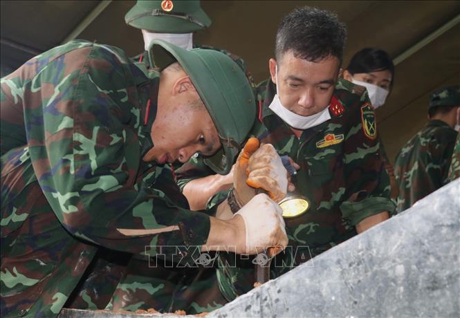 Lực lượng làm nhiệm vụ lấy mẫu hài cốt liệt sĩ chưa xác định được thông tin. Ảnh: Chu Hiệu - TTXVN 