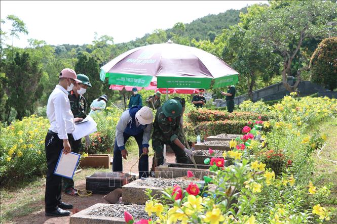 Lấy mẫu hài cốt liệt sĩ tại Huế. Ảnh: Mai Trang - TTXVN