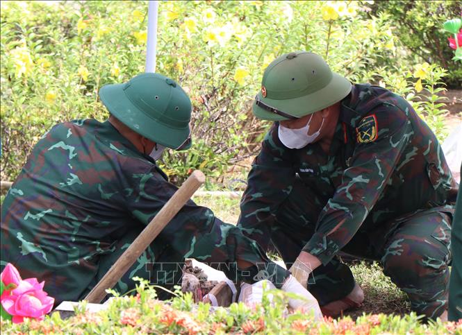 Lấy mẫu hài cốt liệt sĩ tại Huế. Ảnh: Mai Trang - TTXVN