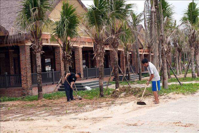 Người dân vệ sinh môi trường, cảnh quan trước các nhà hàng tại khu dịch vụ du lịch ven biển Cửa Việt (Quảng Trị). Ảnh: Tá Chuyên - TTXVN