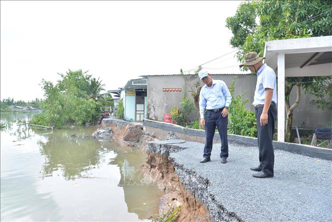 Lãnh đạo Sở Nông nghiệp và Môi trường tỉnh Đồng Tháp khảo sát hiện trường vụ sạt lở. Ảnh: Công Trí - TTXVN 