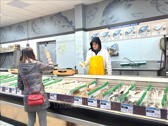 Nhân viên chuẩn bị sơ chế hải sản cho khách tại siêu thị H-Mart ở bang Maryland. Ảnh: Đoàn Hùng - PV TTXVN tại Mỹ
