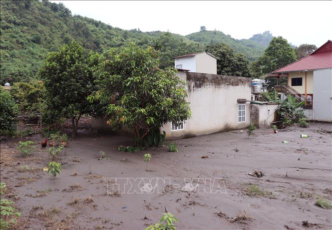 Lớp bùn đất dày phủ kín nền nhà của người dân sau mưa lớn. Ảnh: Đức Thọ - TTXVN