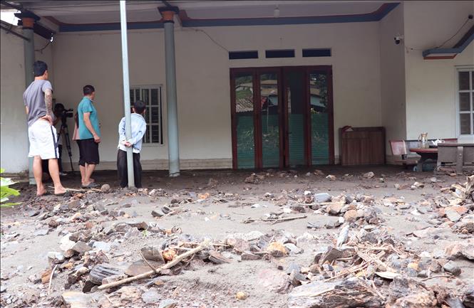 Lớp bùn đất dày phủ kín nền nhà của người dân sau mưa lớn. Ảnh: Đức Thọ - TTXVN