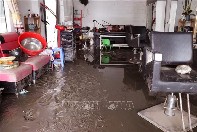 Bùn đất bồi lấp nhà cửa, phương tiện và mặt bằng kinh doanh, ảnh hưởng nghiêm trọng đến đời sống của người dân. Ảnh: Đức Thọ - TTXVN