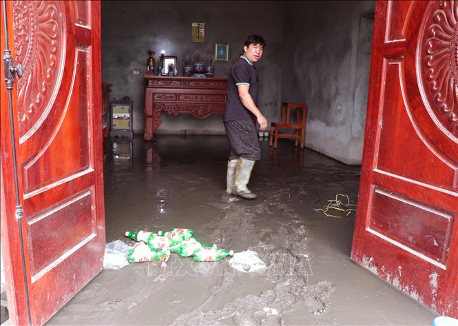 Bùn đất bồi lấp nhà cửa, phương tiện và mặt bằng kinh doanh, ảnh hưởng nghiêm trọng đến đời sống của người dân. Ảnh: Đức Thọ - TTXVN