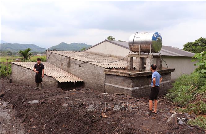 Lớp bùn đất dày phủ kín nhà ở, ảnh hưởng nghiêm trọng đến sinh hoạt của người dân. Ảnh: Đức Thọ - TTXVN