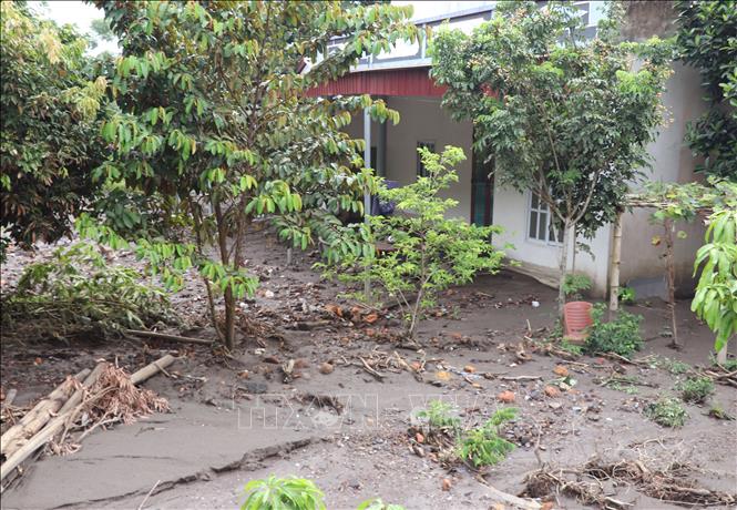 Lớp bùn đất dày phủ kín nền nhà của người dân sau mưa lớn. Ảnh: Đức Thọ - TTXVN