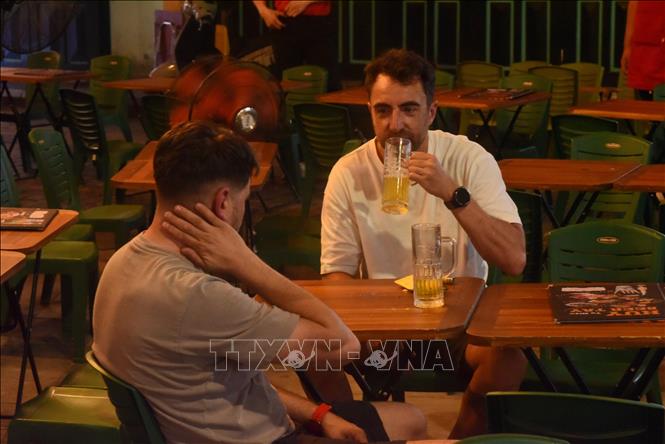 Du khách thưởng thức bia trên phố Tạ Hiện (Hà Nội). Ảnh: Tuyết Mai - TTXVN