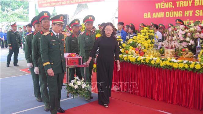 Các đại biểu thực hiện di quan đến khu vực an tấng hài cốt liệt sĩ. Ảnh: Hương Thu - TTXVN                              