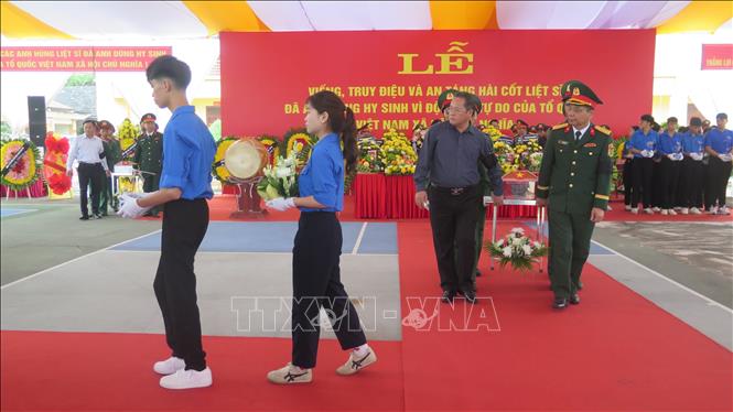 Các đại biểu thực hiện di quan đến khu vực an táng hài cốt liệt sĩ. Ảnh: Hương Thu - TTXVN                        