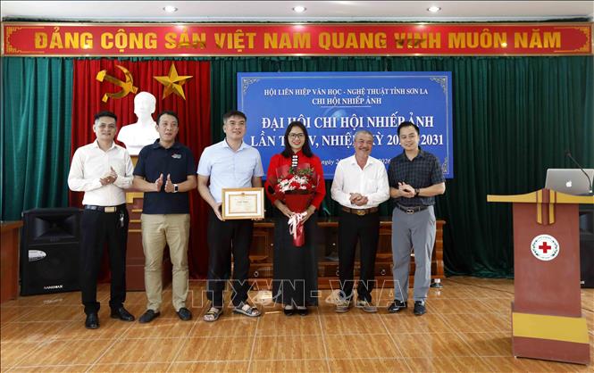 Họa sĩ Lê Chương, Chủ tịch Hội Liên hiệp Văn học Nghệ thuật tỉnh Sơn La (thứ 2, bên phải) tặng Giấy khen cho tập thể Chi hội Nhiếp ảnh tỉnh. Ảnh: Quang Quyết - TTXVN