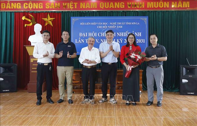 Họa sĩ Lê Chương, Chủ tịch Hội Liên hiệp Văn học Nghệ thuật tỉnh Sơn La (thứ 3, bên trái) tặng hoa chúc mừng Ban Chấp hành Chi hội Nhiếp ảnh tỉnh Sơn La khóa 5, nhiệm kỳ 2026 - 2031. Ảnh: Quang Quyết - TTXVN