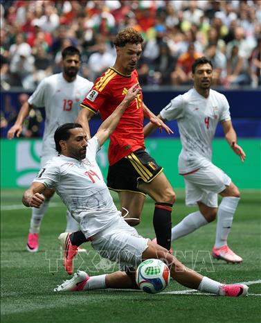 Tiền vệ Iran Saman Ghoddos nỗ lực ngăn chặn pha đi bóng của hậu vệ Bỉ Thomas Meunier. Ảnh: THX/TTXVN phát