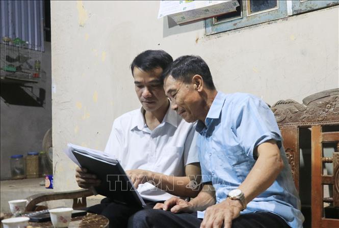 Cán bộ xã Việt Hồng (Lào Cai) đến từng hộ dân tuyên truyền và lấy ý kiến nhân dân về chủ trương sáp nhập thôn. Ảnh: Anh Thùy - TTXVN