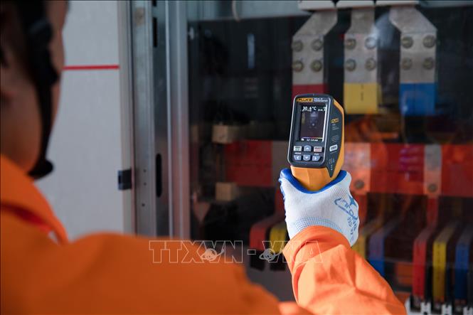 Công nhân EVNHANOI kiểm tra tủ điện nhằm phát hiện sớn các nguy cơ phát sinh sự cố thông qua thiết bị đo nhiệt. Ảnh: Quốc Lũy - TTXVN