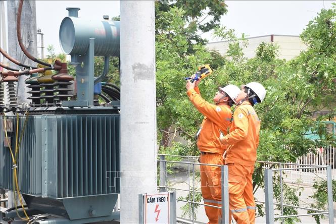 Công nhân EVNHANOI kiểm tra trạm biến áp nhằm phát hiện sớn các nguy cơ phát sinh sự cố, đặc biệt là các điểm phát nhiệt bất thường có thể dẫn đến quá tải hoặc cháy nổ thiết bị điện. Ảnh: Quốc Lũy - TTXVN