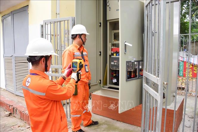 Công nhân EVNHANOI kiểm tra tủ điện  nhằm phát hiện sớn các nguy cơ phát sinh sự cố thông qua thiết bị đo nhiệt. Ảnh: Quốc Lũy - TTXVN