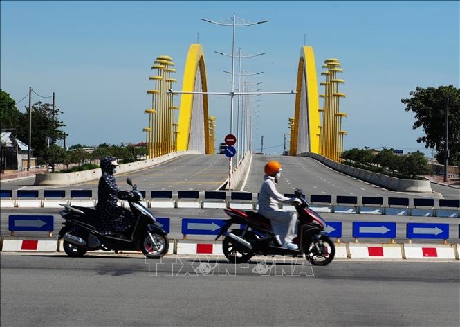 Mặc đồ bảo hộ chống nắng nóng gay gắt, khi tham gia giao thông ở bờ Nam cầu Nguyễn Hoàng, phường Thủy Xuân, thành phố Huế. Ảnh: Nguyên Lý -TTXVN