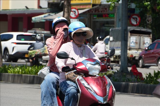 Người dân mặc đồ bảo hộ chống nắng nóng gay gắt. Ảnh: Nguyên Lý-TTXVN