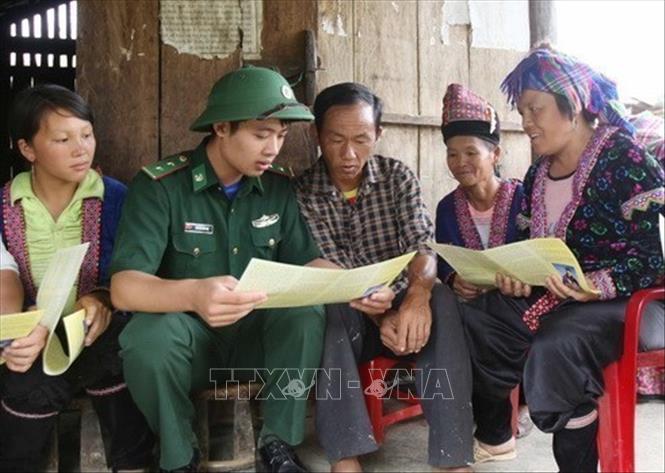 Cán bộ chiến sĩ Đội vận động quần chúng đồn Biên phòng Pa Tần xuống bản Pho 2, xã Pa Tần, huyện Phong Thổ (Lai Châu) tuyền truyền và phát tờ rơi tới người dân về tác hại của ma túy. Ảnh: Quý Trung - TTXVN