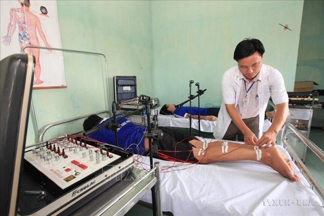 Bác sỹ Trung tâm Chữa bệnh - Giáo dục - Lao động xã hội tỉnh Bình Phước sử dụng các thiết bị hiện đại phục hồi chức năng cho các đối tượng cai nghiện ma túy. Ảnh: Anh Tuấn - TTXVN
