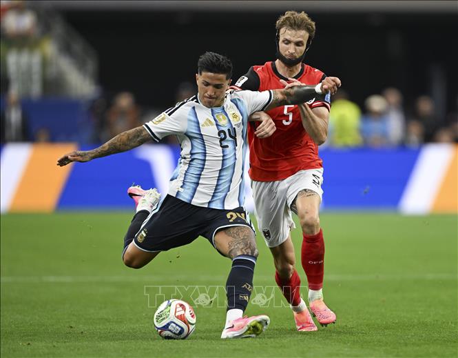 Pha tranh bóng giữa Enzo Fernandez (trái) của tuyển Argentina với tuyển thủ Áo. Ảnh: THX/TTXVN