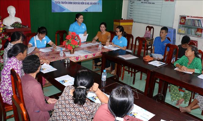 Cán bộ Bảo hiểm Xã hội cơ sở Vị Tân và đoàn thể địa phương tuyên truyền, vận động người dân tham gia bảo hiểm xã hội. Ảnh: Duy Khương - TTXVN