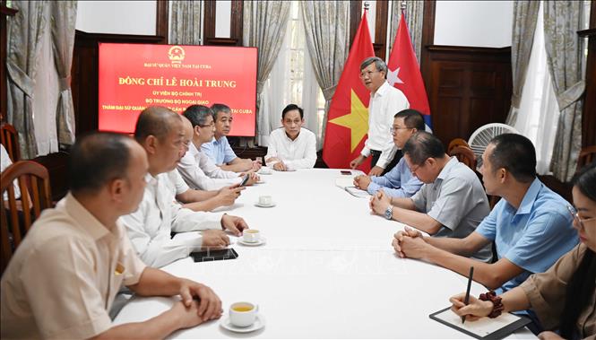 Đại sứ Việt Nam tại Cuba Lê Quang Long báo cáo với Bộ trưởng Lê Hoài Trung về tình hình sở tại và cộng đồng người Việt. Ảnh: Việt Hùng - PV TTXVN tại Cuba