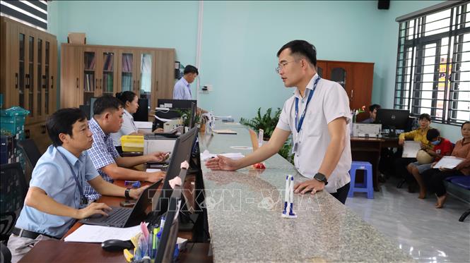Ông Trịnh Quốc Phương (đứng), Trưởng phòng kinh tế xã Bom Bo, kiểm tra, đôn đốc bộ chuyên viên phụ trách đơn vị tại bộ phận 1 cửa của Trung tâm hành chính công. Ảnh: Đậu Tất Thành – TTXVN