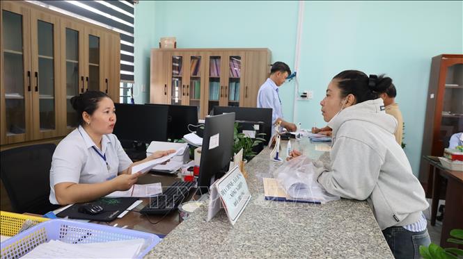 Cán bộ trung tâm phục vụ hành chính công xã Bom Bo tiếp nhận, hướng dẫn người dân làm thủ tục hành chính. Ảnh: Đậu Tất Thành – TTXVN