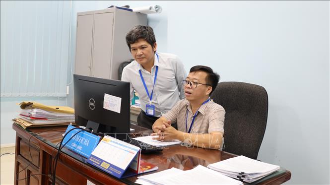 Ông Lê Tấn Bình (đứng), Trưởng Phòng Kinh tế, Hạ tầng và Đô thị phường Chơn Thành kiểm tra đôn đốc cán bộ công chức đơn vị trong quá trình thực hiện nhiệm vụ. Ảnh: Đậu Tất Thành – TTXVN