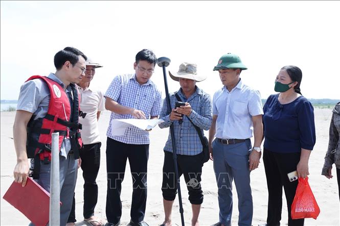 Các lực lượng lập biên bản, cắm mốc theo sơ đồ được cấp phép khai thác cát trên dòng sông Hồng qua Cẩm Khê (Phú Thọ). Ảnh: TTXVN
 