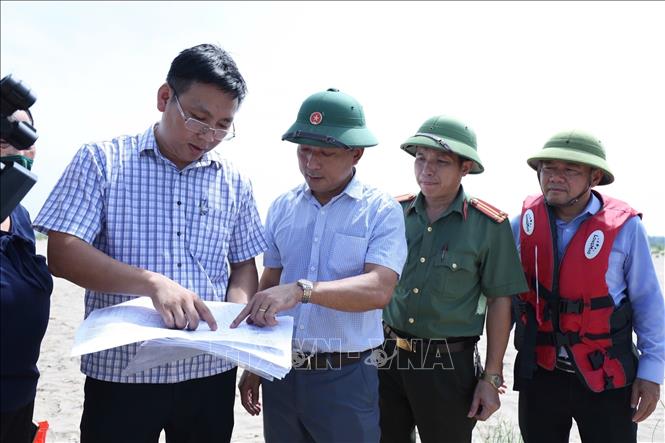 Các lực lượng lập biên bản, cắm mốc theo sơ đồ được cấp phép khai thác cát trên dòng sông Hồng qua Cẩm Khê. Ảnh: TTXVN  