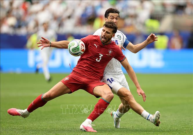 Pha tranh bóng giữa hậu vệ Bồ Đào Nha Ruben Dias (trước) và tiền đạo Uzbekistan Eldor Shomurodov. Ảnh: THX/TTXVN